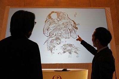 北斎漫画を「触って」拡大できる「Touch the Hokusai Manga」。東京都の印刷会社、凸版印刷がスキャンした北斎漫画から手作業で約1000のイラストを切り抜いた。日本以外で上映されるのは初めて＝28日撮影（photo: Yuriko Anzai / 本紙）