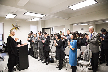 中垣顕實師の主導で黙とうを捧げる追悼式参加者たち（photo: ほくほく会提供）